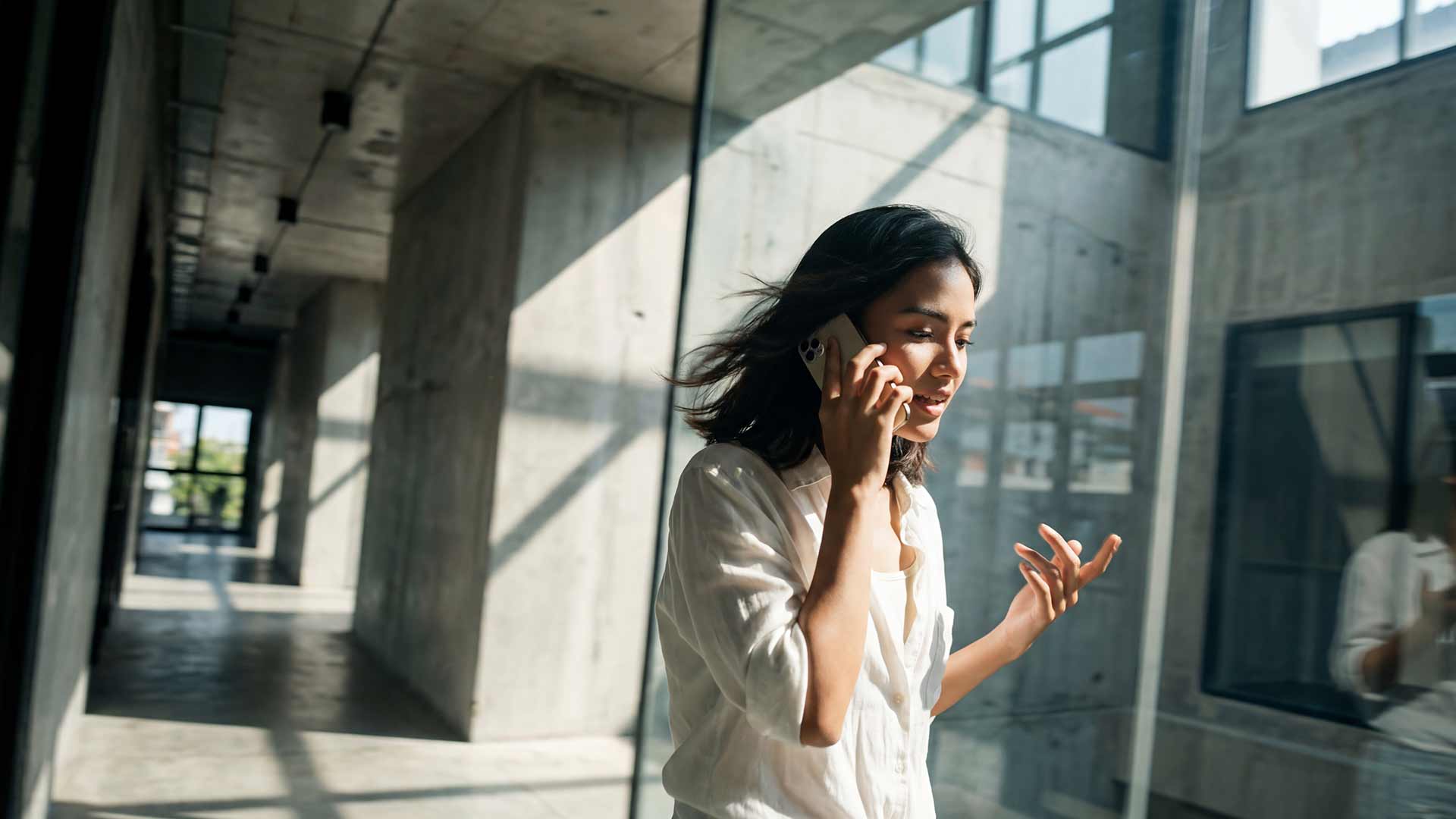 SEO strategist on client call in modern concrete building