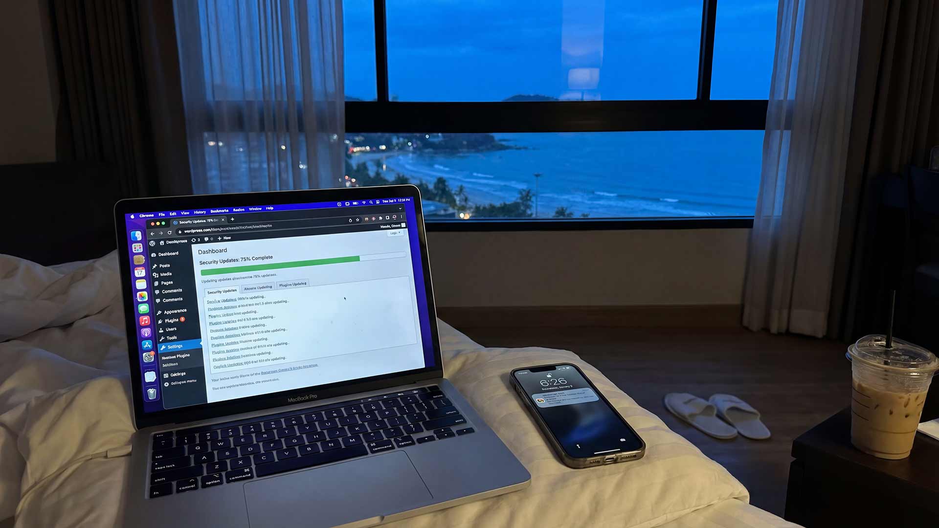 WordPress dashboard at dusk with Phuket coastline view through window