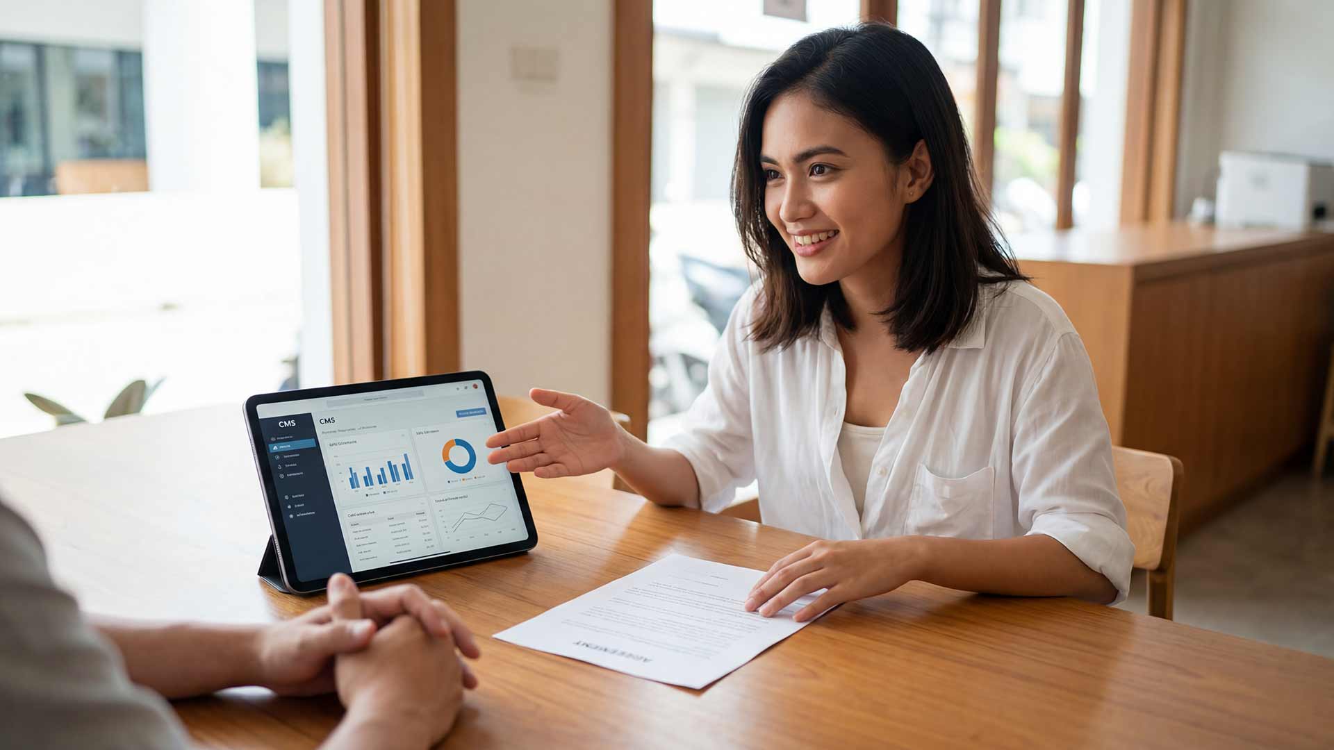 Client meeting with CMS dashboard on tablet and documentation
